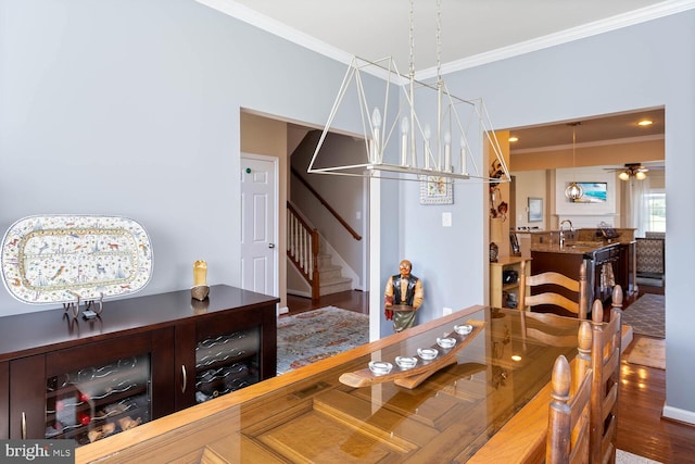 dining space featuring ceiling fan, crown molding, stairway, and wood finished floors