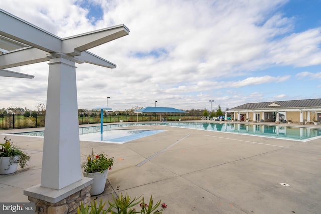 community pool featuring fence and a patio