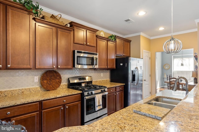 kitchen with stainless steel appliances, hanging light fixtures, a sink, and light stone counters