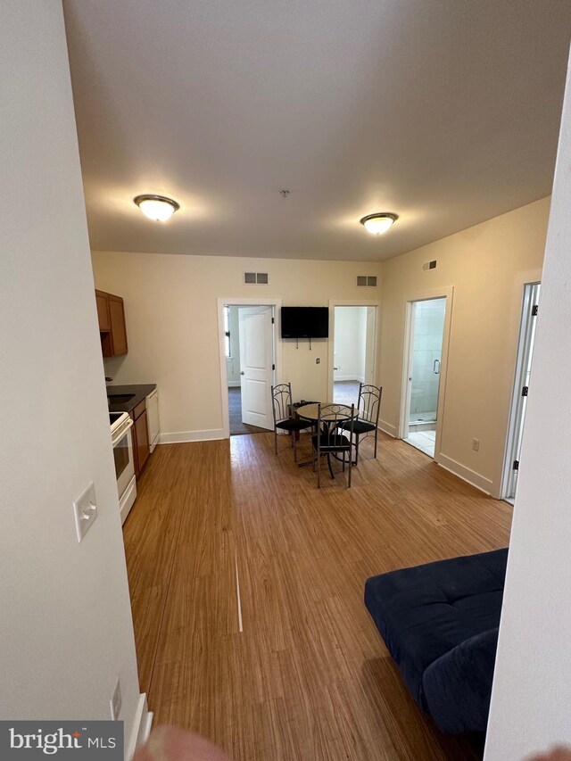 kitchen featuring white range with electric stovetop and hardwood / wood-style flooring