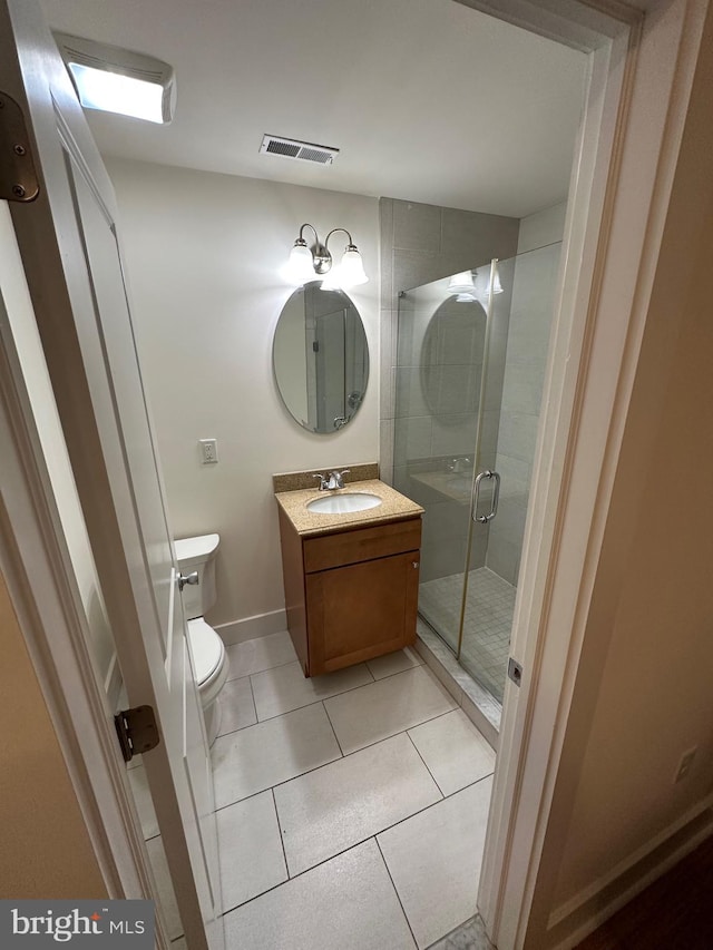 bathroom featuring vanity, toilet, an enclosed shower, and tile patterned floors