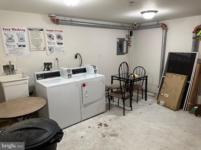 clothes washing area with washer and clothes dryer, electric panel, and sink