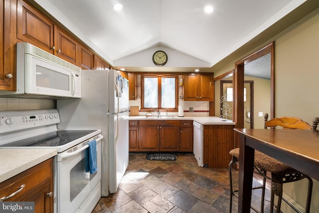 kitchen featuring white appliances, backsplash, sink, and vaulted ceiling