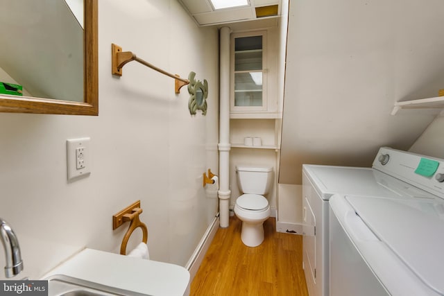 clothes washing area featuring separate washer and dryer and light hardwood / wood-style flooring