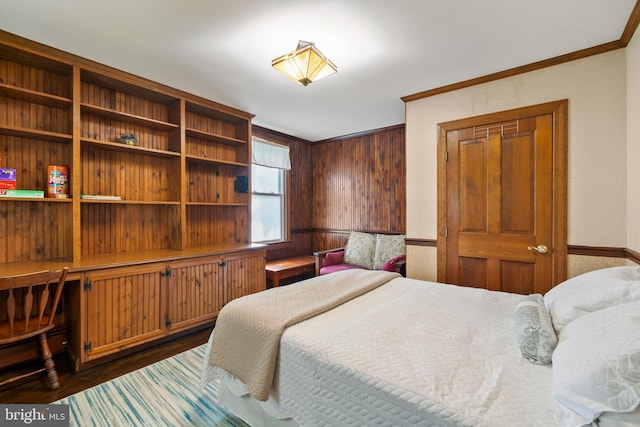 bedroom featuring dark wood-type flooring, wooden walls, and ornamental molding