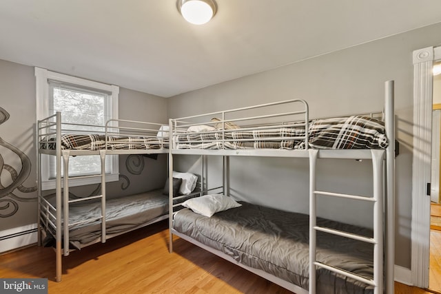 bedroom featuring hardwood / wood-style floors and a baseboard radiator