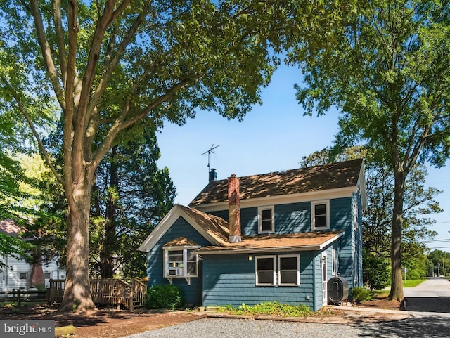 view of front facade featuring a chimney and a wooden deck