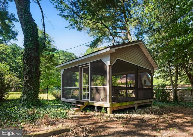 view of home's exterior with a sunroom and fence