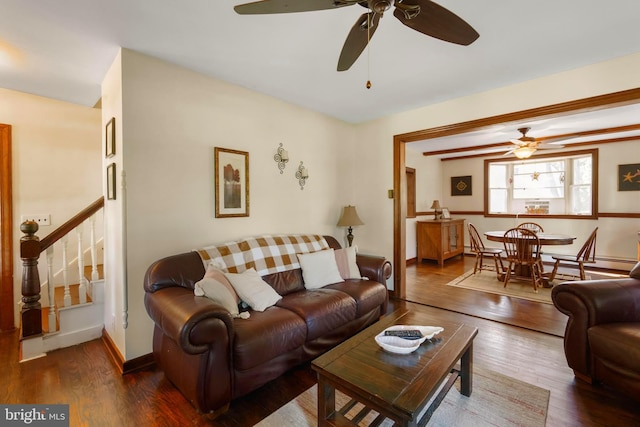 living room featuring stairway, wood finished floors, a ceiling fan, and baseboards