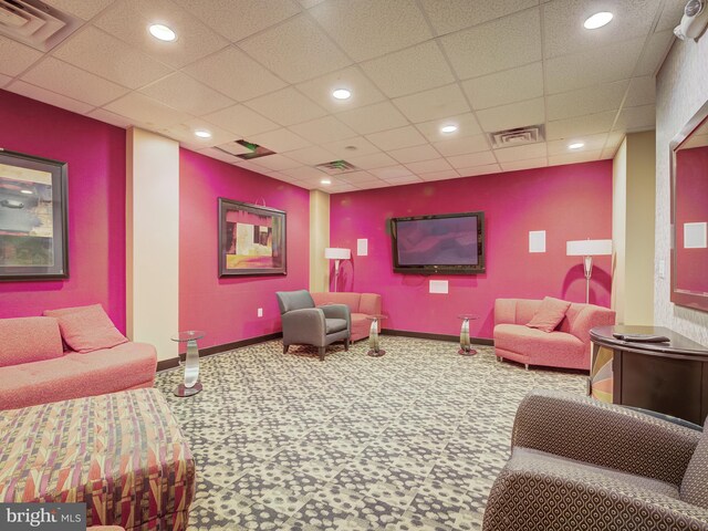 carpeted living room with a drop ceiling