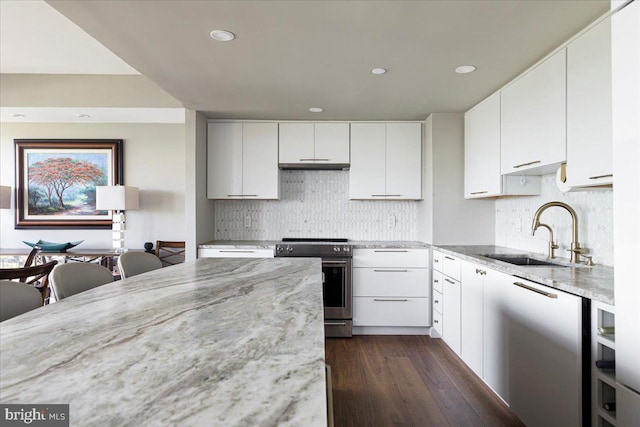 kitchen with light stone counters, sink, white cabinets, and stainless steel appliances