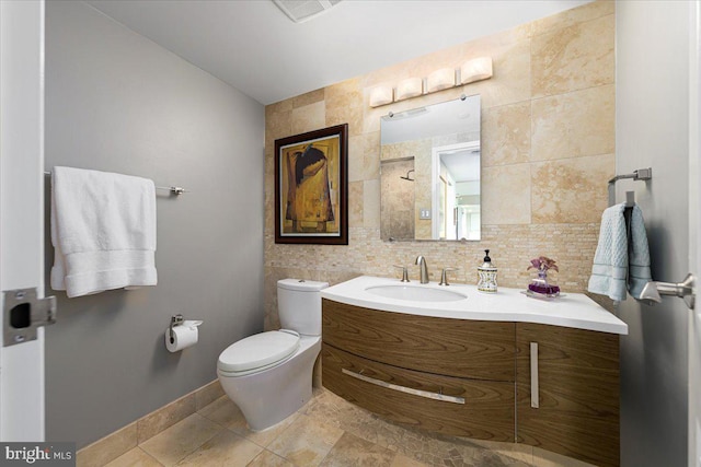 bathroom with backsplash, vanity, toilet, and tile walls