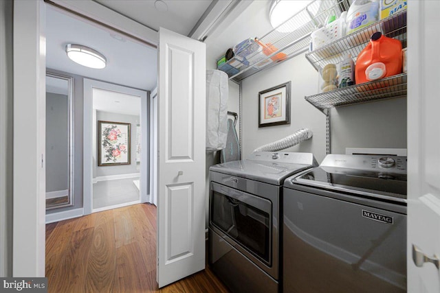 laundry area with washing machine and dryer and hardwood / wood-style floors