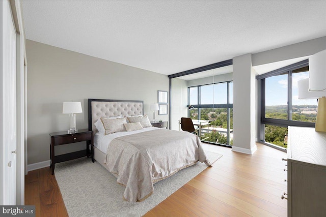 bedroom featuring a textured ceiling, light wood-type flooring, and multiple windows