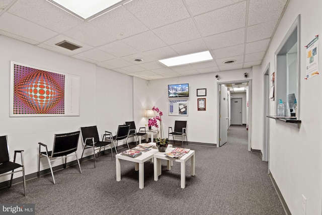 interior space featuring baseboards, visible vents, dark carpet, and a drop ceiling