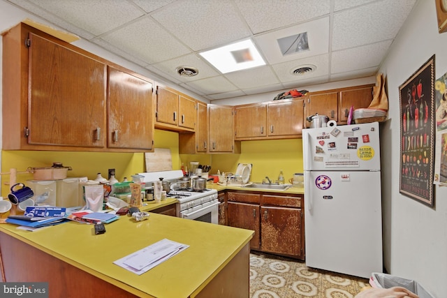 kitchen with brown cabinets, white appliances, and light countertops