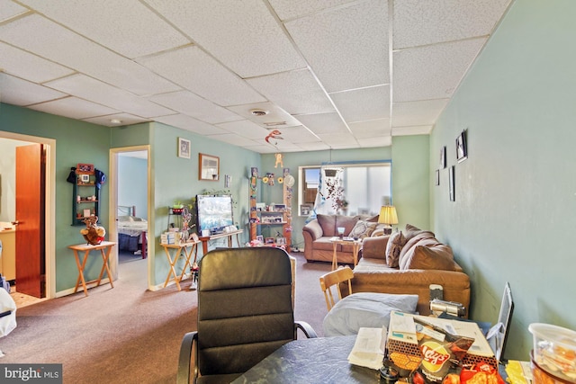 living area with carpet, a paneled ceiling, and baseboards