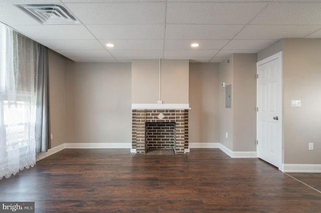 unfurnished living room featuring dark hardwood / wood-style flooring and a drop ceiling