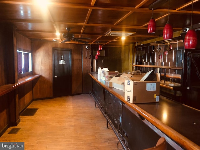 bar featuring coffered ceiling, wood-type flooring, ceiling fan, and wooden walls