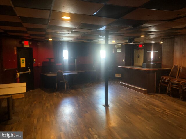 basement featuring bar area and dark wood-type flooring