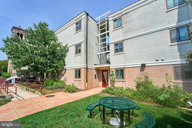 back of house with a lawn and a patio