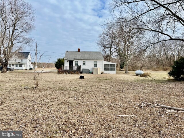 view of front of property featuring a sunroom, a deck, and a front yard