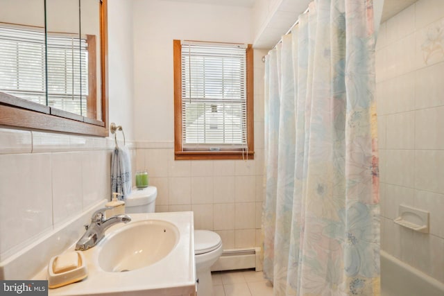 full bathroom with tile walls, plenty of natural light, a baseboard heating unit, and tile patterned floors