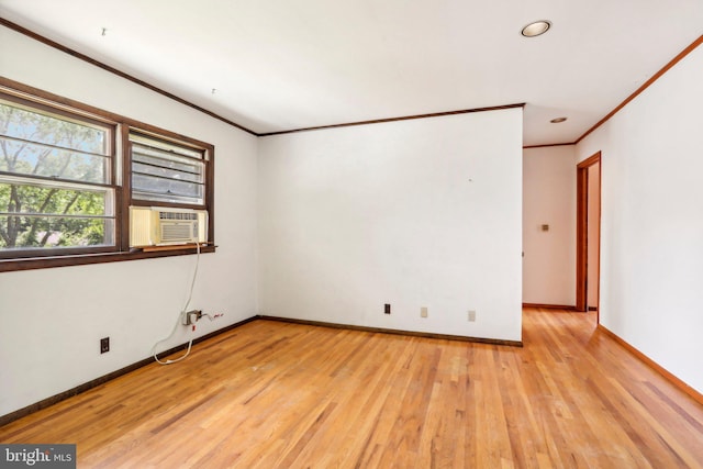 empty room featuring light wood-type flooring, cooling unit, and crown molding