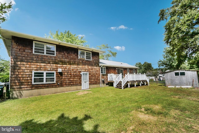 rear view of property with a lawn, an outdoor structure, and a deck