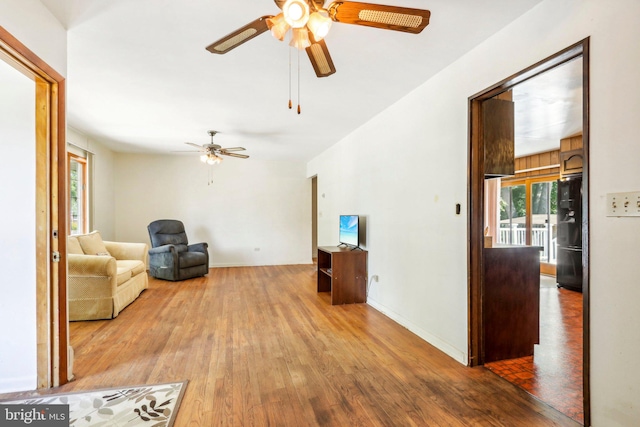 living room featuring dark wood-type flooring and ceiling fan