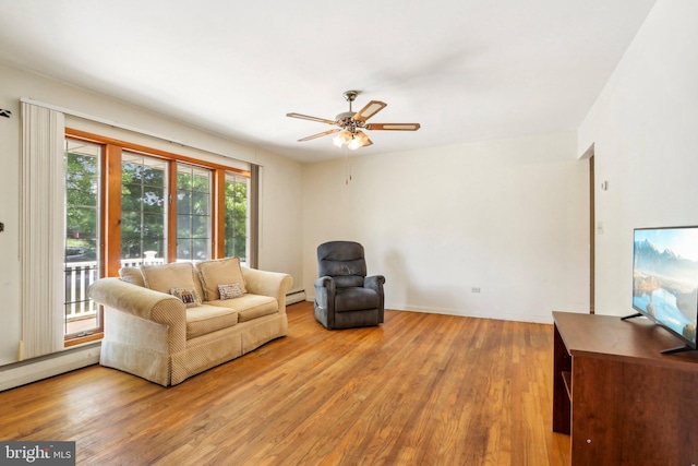 living room with baseboard heating, hardwood / wood-style flooring, and ceiling fan