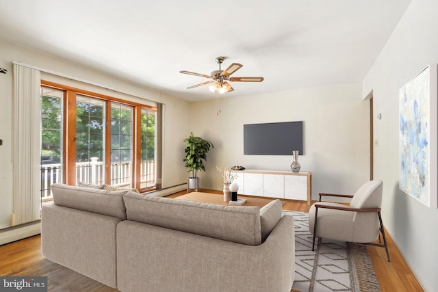 living room featuring a baseboard heating unit, hardwood / wood-style floors, and ceiling fan