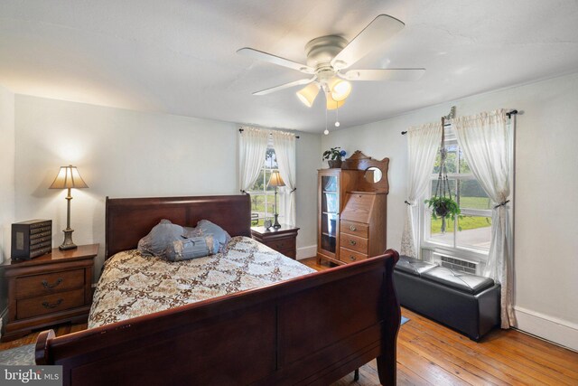 bedroom featuring multiple windows, light hardwood / wood-style flooring, and ceiling fan