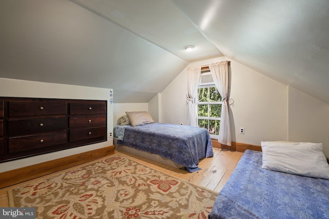 bedroom featuring lofted ceiling and light hardwood / wood-style flooring