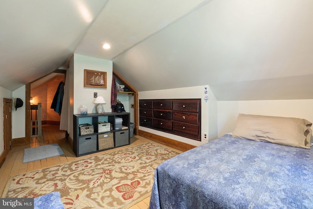 bedroom with light hardwood / wood-style floors and vaulted ceiling