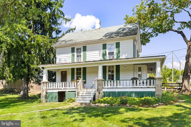 view of front of house with a front yard and covered porch