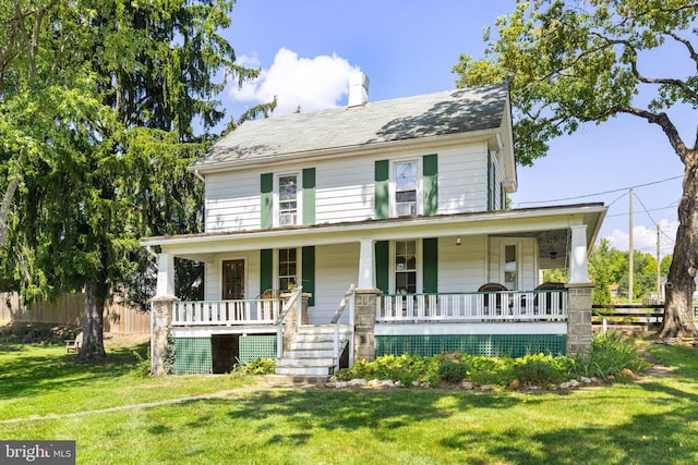 view of front of home with covered porch, fence, and a front lawn