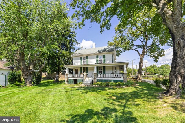 view of front of home with covered porch and a front lawn