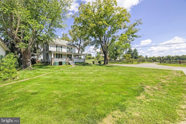 view of yard with a porch and fence