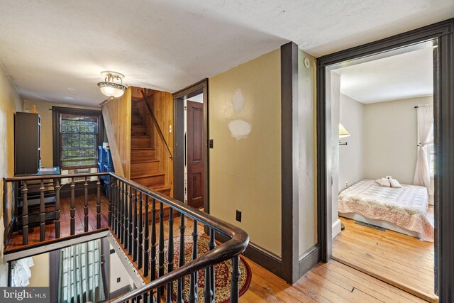 hall featuring hardwood / wood-style floors and a textured ceiling