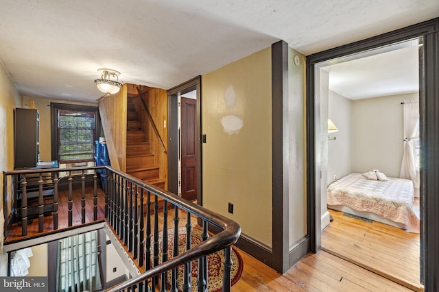 hall featuring stairs, wood finished floors, and baseboards