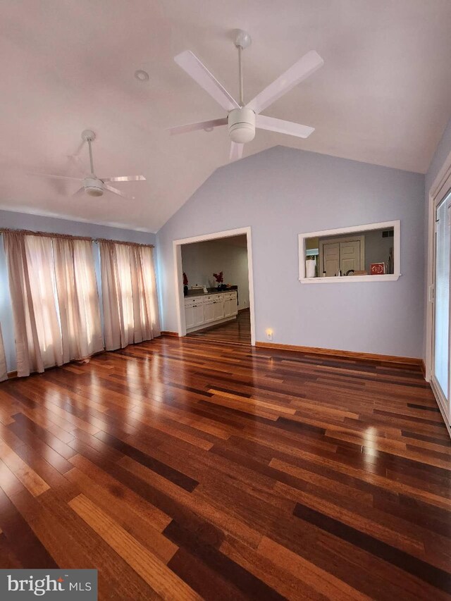 unfurnished living room featuring lofted ceiling, plenty of natural light, a ceiling fan, and wood finished floors