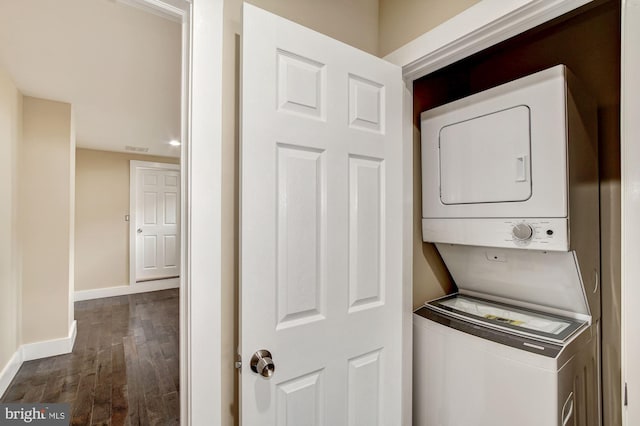 laundry room with laundry area, dark wood-style floors, baseboards, and stacked washer / drying machine