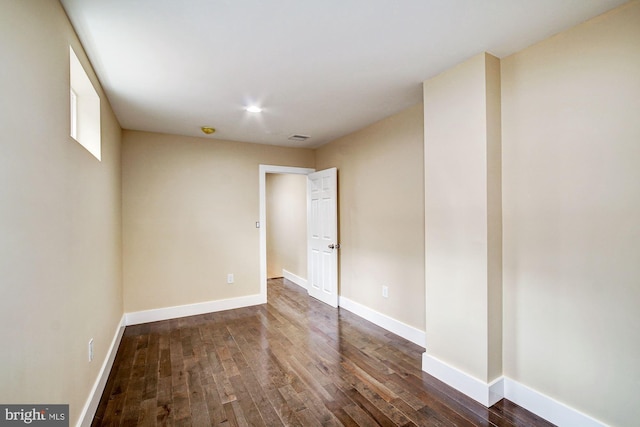 empty room featuring visible vents, baseboards, and wood finished floors