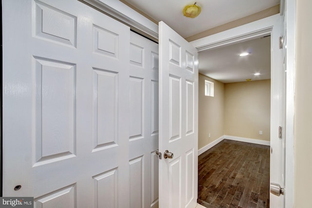 corridor featuring baseboards and wood finished floors