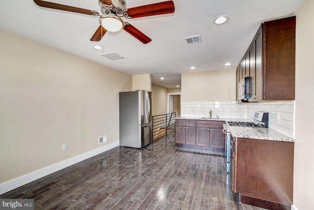 kitchen featuring dark hardwood / wood-style floors, stainless steel appliances, sink, decorative backsplash, and ceiling fan