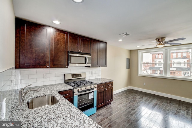 kitchen with stainless steel appliances, sink, hardwood / wood-style floors, and decorative backsplash