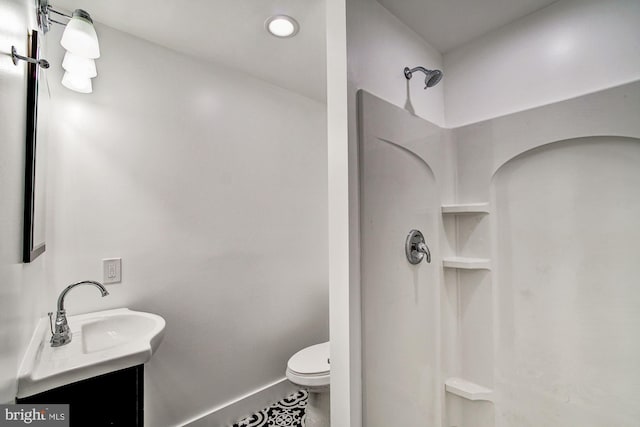 bathroom featuring a shower, vanity, toilet, and tile patterned floors