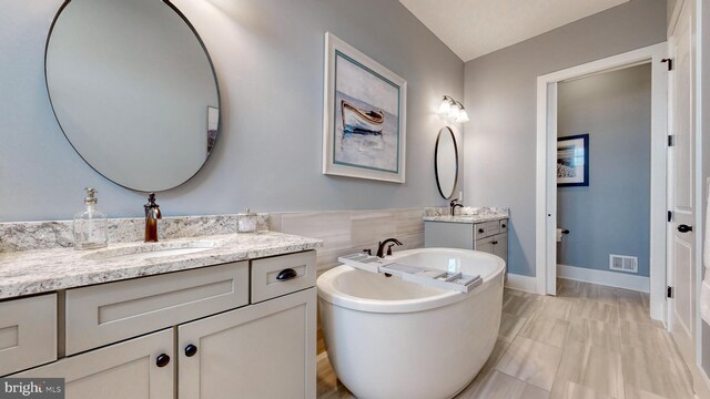 bathroom with a tub and vanity