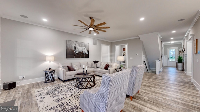 living room with crown molding, ceiling fan, and light wood-type flooring